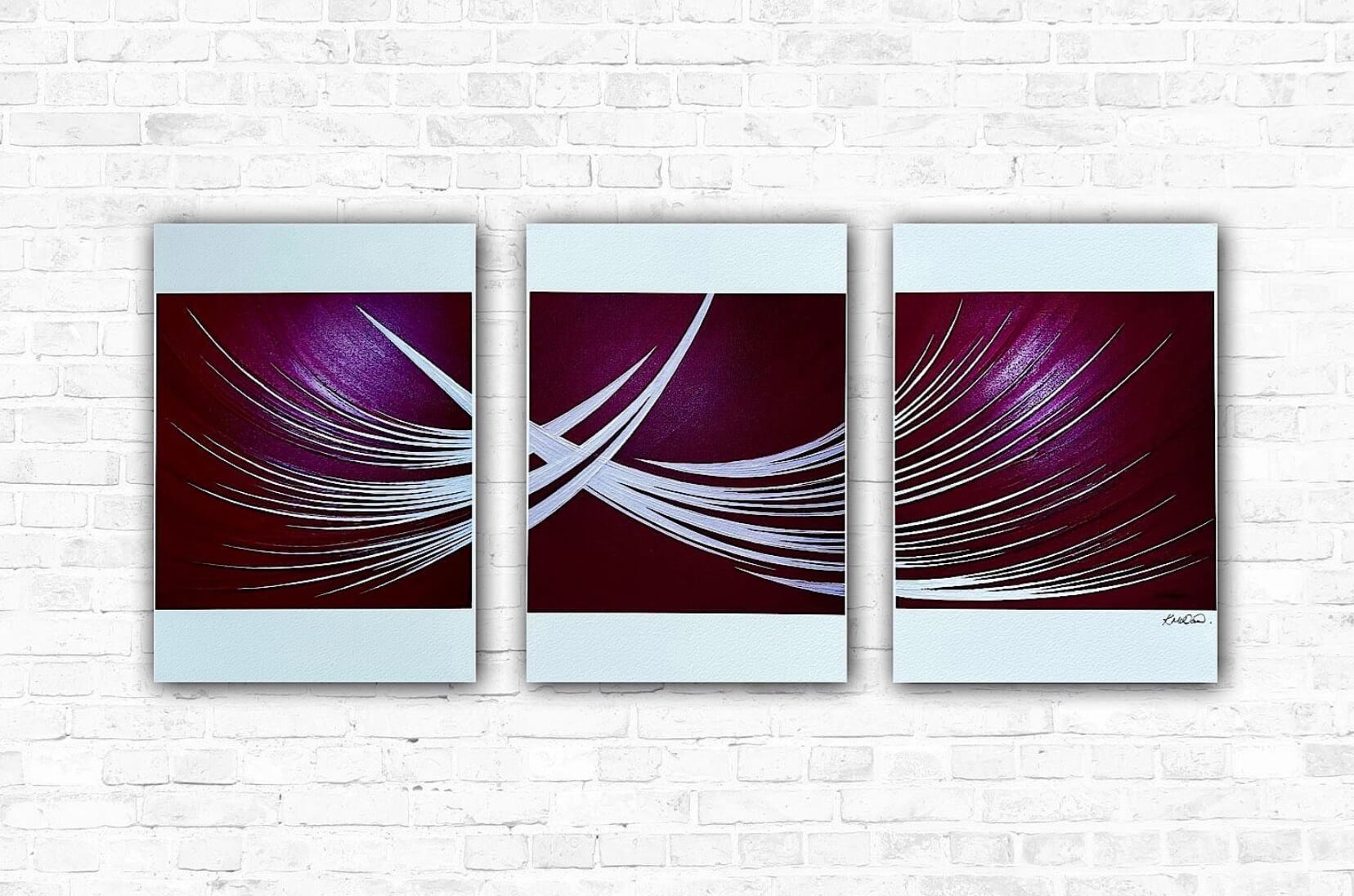 A set of three modern abstract art prints with red and white colours, displayed on a white brick wall background.