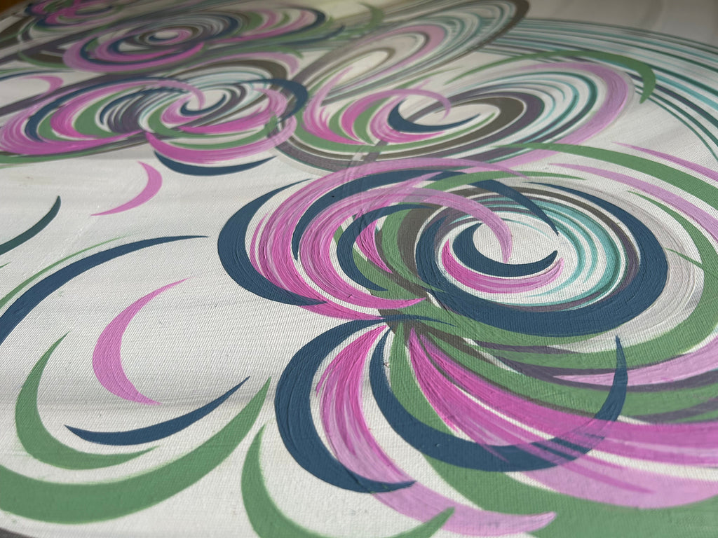 Close up of a abstract painting with pink, blue and green paint stokes and floral design