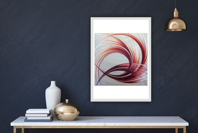 Abstract artwork with an orange and white pattern on a dark wall with decorative items on a table.