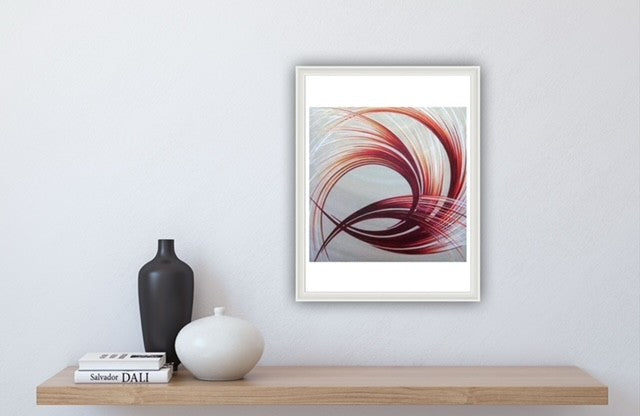 Framed orange and white abstract art piece with a colourful pattern on a wall above a wooden shelf with decorative items.